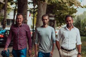 After a productive day at work, a group of diverse colleagues enjoy a leisurely stroll through a modern and natural urban setting photo