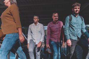A diverse group of businessmen and colleagues walking together by their workplace, showcasing collaboration and teamwork in the company. photo