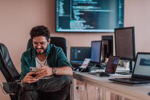 A programmer diligently testing smartphone applications while sitting in their office. photo