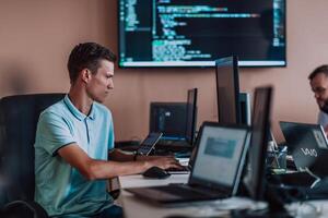 A programmer diligently testing smartphone applications while sitting in their office. photo