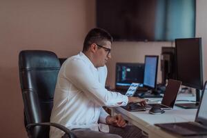 A programmer diligently testing smartphone applications while sitting in their office. photo