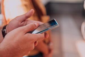 Closeup photo of businessman hand utilizes his smartphone outdoors, showcasing the seamless integration of technology and mobility in modern professional life.