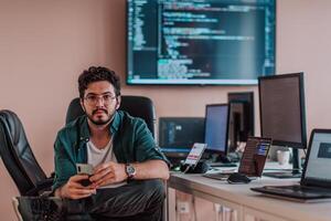 A programmer diligently testing smartphone applications while sitting in their office. photo