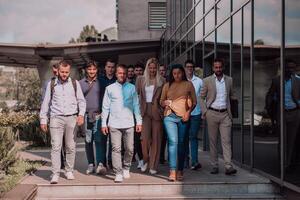 A diverse group of businessmen and colleagues walking together by their workplace, showcasing collaboration and teamwork in the company. photo