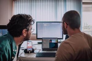 Programmers engrossed in deep collaboration, diligently working together to solve complex problems and develop innovative mobile applications with seamless functionality. photo