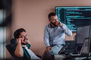 Programmers engrossed in deep collaboration, diligently working together to solve complex problems and develop innovative mobile applications with seamless functionality. photo