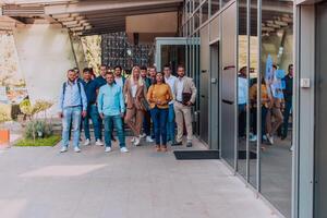 A diverse group of businessmen and colleagues walking together by their workplace, showcasing collaboration and teamwork in the company. photo