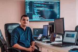 A programmer diligently testing smartphone applications while sitting in their office. photo