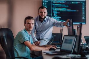 Programmers engrossed in deep collaboration, diligently working together to solve complex problems and develop innovative mobile applications with seamless functionality. photo