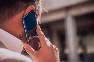 A businessman using his smartphone outdoors, showcasing the seamless integration of technology and mobility in modern professional life. photo