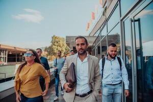 A diverse group of businessmen and colleagues walking together by their workplace, showcasing collaboration and teamwork in the company. photo