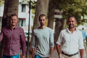After a productive day at work, a group of diverse colleagues enjoy a leisurely stroll through a modern and natural urban setting photo
