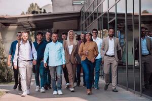 A diverse group of businessmen and colleagues walking together by their workplace, showcasing collaboration and teamwork in the company. photo