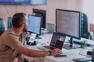 A programmer diligently testing smartphone applications while sitting in their office. photo