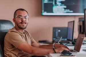 A programmer diligently testing smartphone applications while sitting in their office. photo