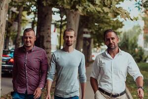 After a productive day at work, a group of diverse colleagues enjoy a leisurely stroll through a modern and natural urban setting photo