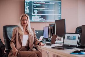 A businesswoman sitting in a programmer's office surrounded by computers, showing her expertise and dedication to technology. photo