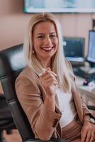 A businesswoman sitting in a programmer's office surrounded by computers, showing her expertise and dedication to technology. photo