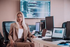 A businesswoman sitting in a programmer's office surrounded by computers, showing her expertise and dedication to technology. photo