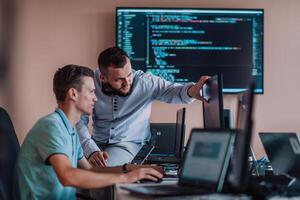 Programmers engrossed in deep collaboration, diligently working together to solve complex problems and develop innovative mobile applications with seamless functionality. photo