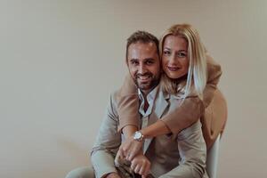 A business couple posing for a photograph together against a beige backdrop, capturing their professional partnership and creating a timeless image of unity and success. photo