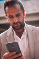 A businessman using his smartphone outdoors, showcasing the seamless integration of technology and mobility in modern professional life. photo