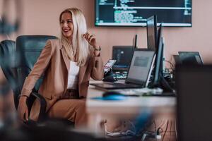 A businesswoman sitting in a programmer's office surrounded by computers, showing her expertise and dedication to technology. photo