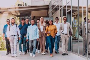 A diverse group of businessmen and colleagues walking together by their workplace, showcasing collaboration and teamwork in the company. photo