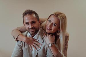 A business couple posing for a photograph together against a beige backdrop, capturing their professional partnership and creating a timeless image of unity and success. photo