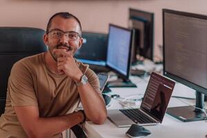 A programmer diligently testing smartphone applications while sitting in their office. photo