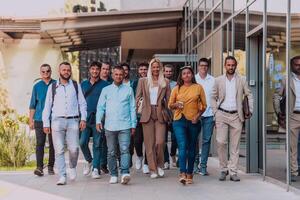 A diverse group of businessmen and colleagues walking together by their workplace, showcasing collaboration and teamwork in the company. photo