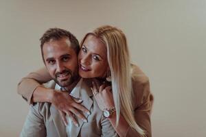 un negocio Pareja posando para un fotografía juntos en contra un beige fondo, capturar su profesional camaradería y creando un eterno imagen de unidad y éxito. foto