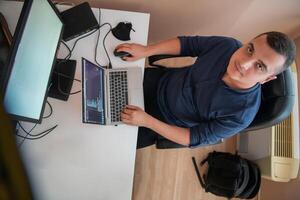 Top view of programmer diligently testing smartphone applications while sitting in their office. photo
