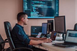 A programmer diligently testing smartphone applications while sitting in their office. photo