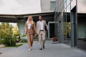Modern business couple after a long day's work, walking together towards the comfort of their home, embodying the perfect blend of professional success and personal contentment. photo