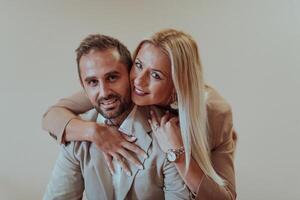 A business couple posing for a photograph together against a beige backdrop, capturing their professional partnership and creating a timeless image of unity and success. photo