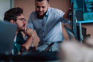Programmers engrossed in deep collaboration, diligently working together to solve complex problems and develop innovative mobile applications with seamless functionality. photo