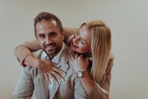 A business couple posing for a photograph together against a beige backdrop, capturing their professional partnership and creating a timeless image of unity and success. photo