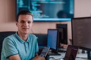 A programmer diligently testing smartphone applications while sitting in their office. photo