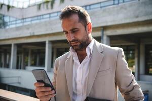 A businessman using his smartphone outdoors, showcasing the seamless integration of technology and mobility in modern professional life. photo