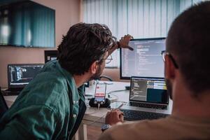 Programmers engrossed in deep collaboration, diligently working together to solve complex problems and develop innovative mobile applications with seamless functionality. photo