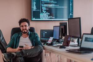 A programmer diligently testing smartphone applications while sitting in their office. photo