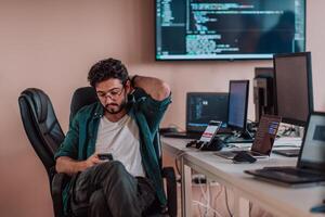 A programmer diligently testing smartphone applications while sitting in their office. photo