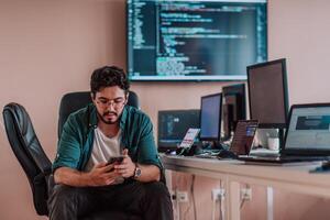 A programmer diligently testing smartphone applications while sitting in their office. photo