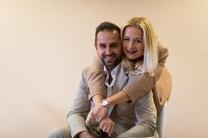 A business couple posing for a photograph together against a beige backdrop, capturing their professional partnership and creating a timeless image of unity and success. photo