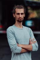 Portrait of a young successful businessman with crossed arms in front of the company photo