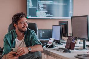 A programmer diligently testing smartphone applications while sitting in their office. photo