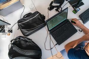 Top view of programmer diligently testing smartphone applications while sitting in their office. photo