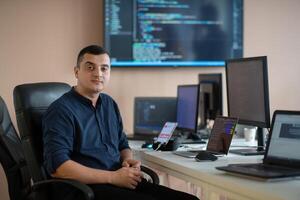 A programmer diligently testing smartphone applications while sitting in their office. photo
