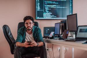 A programmer diligently testing smartphone applications while sitting in their office. photo